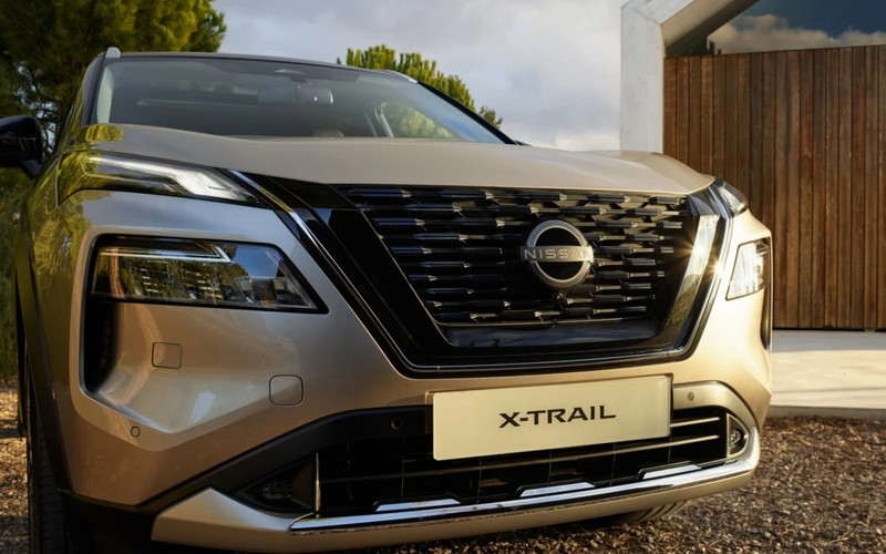 Frontansicht Nissan X-Trail mit Haus im Hintergrund.
