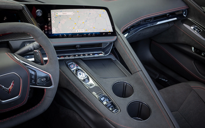 Mittelkonsole der Chevrolet Corvette Stingray Cabrio mit Infotainmentdisplay, Bedienelementen, Fahrmoduswahl und Getränkehaltern.