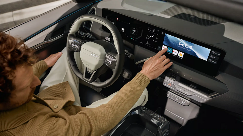 Mann benutzt Display im Cockpit des KIA EV5