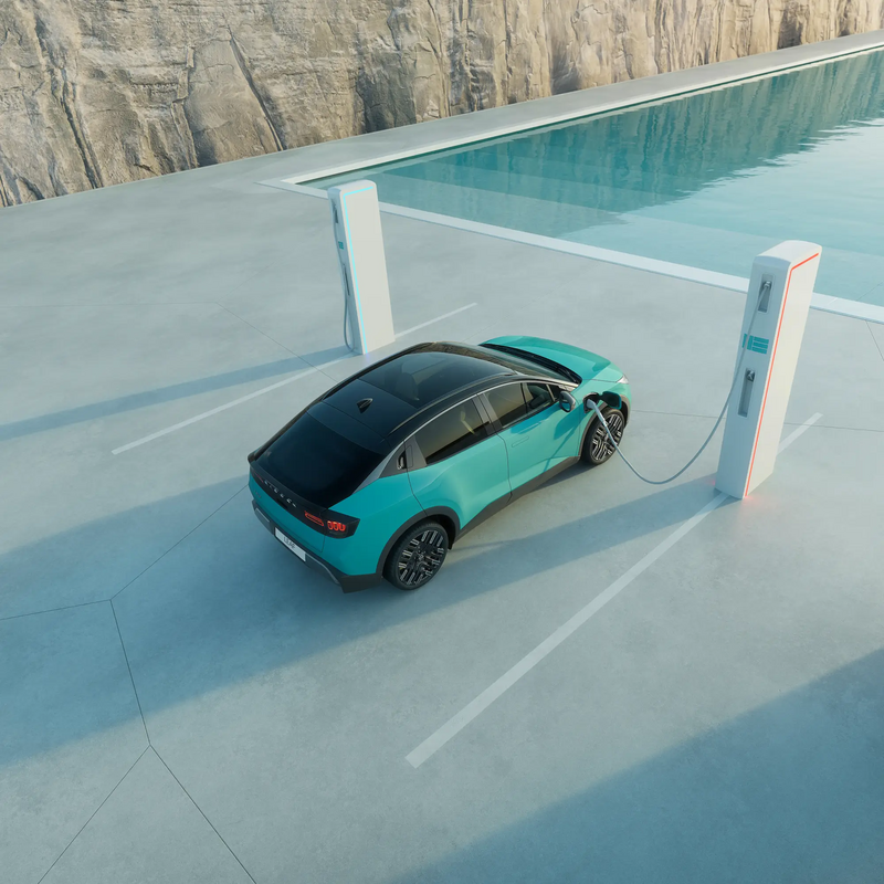 Nissan Leaf parkt vor einem Pool, mit Felshintergrund