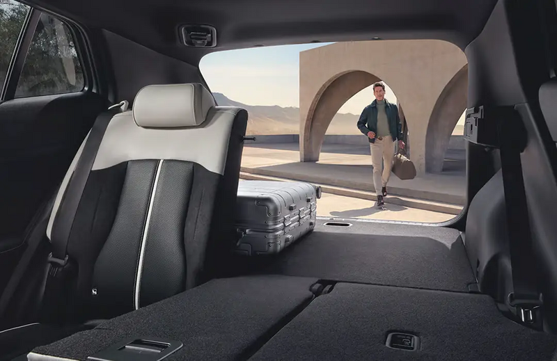 Kia Sportage Hybrid – Kofferraum geöffnet mit Person beim Einladen von Gepäck